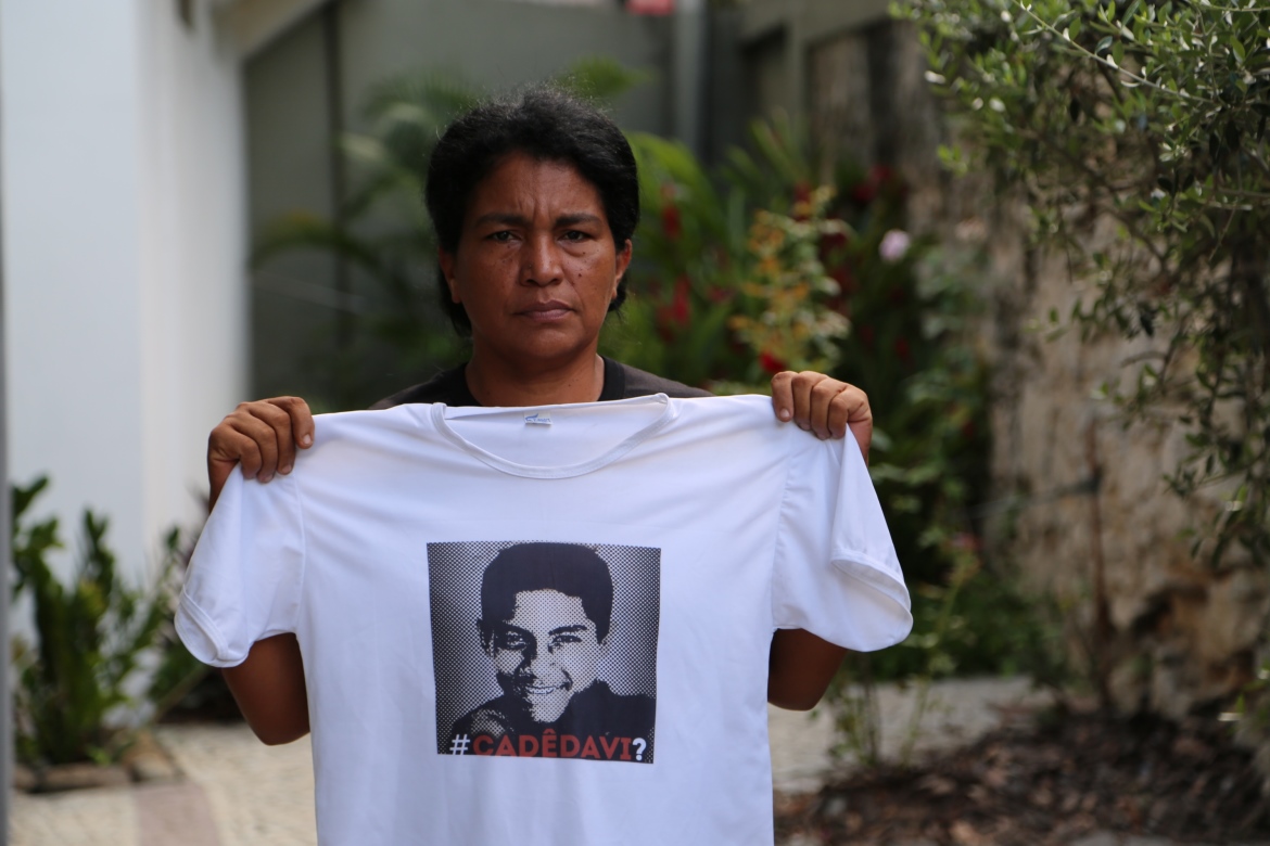 Rute Silva Santos, mãe de Davi, segura uma camiseta com a foto do filho de 16 anos, desaparecido. | ©Thais Herdy / Amnesty International